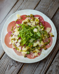 Plato gourmet de carpaccio de ternera con rucula y parmesano