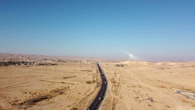 Flying over the curve on highway with cars traffic in the desert Negev on the southern direction to the solar power plant