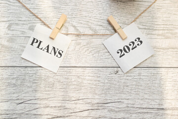 the plan for 2023 is held on clothespins. Wooden background