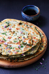 Homemade appetizing scallion pancakes served with soy sauce.