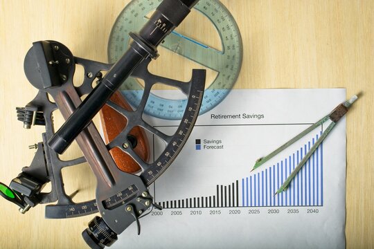 Navigating Retirement Concept With Nautical Theme Of Sextant Protractor And Dividers Arranged Around Compound Interest Chart Set On Navigation Chart