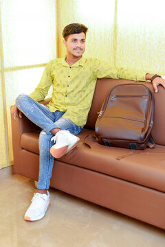 Indian Student Or Business Sitting On Sofa With Casual Bag