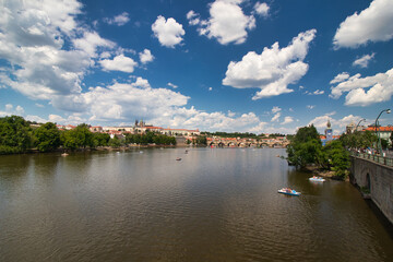Fototapeta na wymiar Pedal boat on Vltava river ,Charles bridge and Prague Castle in background.