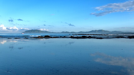 Fototapeta na wymiar Sunrise on the beach in Tamarindo, Costa Rica, with mountains in the distance