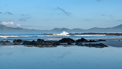 Sunrise on the beach in Tamarindo, Costa Rica, with mountains in the distance