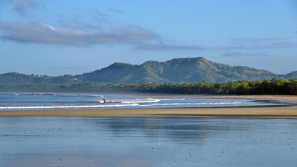 Sunrise on the beach in Tamarindo, Costa Rica, with mountains in the distance