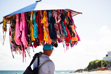 Street vendors walk on the sand of Porto da Barra beach