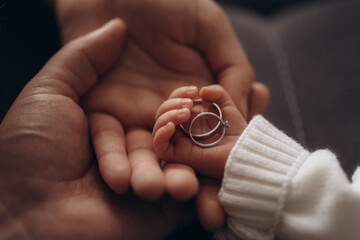 family concept, wedding rings in hands, wedding rings in the hands of a newborn baby. 