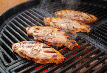 Barbecue lamb saddle back chop steak grilled as close-up on a charcoal grill with fire