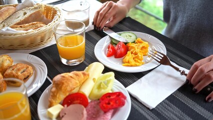 Woman eating breakfast in holiday resort, hotel restaurant or at home on terrace.