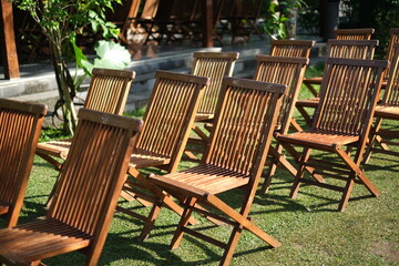 Rows of empty wooden chairs neatly arranged outdoors