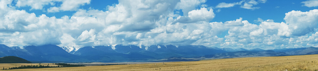 Obraz premium Majestic snow mountain ranges under cloudy sky. Awesome scenery high snow mountains valley ​in low clouds. Atmospheric mountain landscaped, panoramic view.