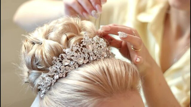 The hairdresser gives the bride a hairstyle. Wedding hairstyle. High quality FullHD footage