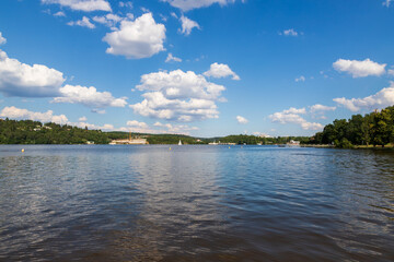 Brno Dam Czech Republic Europe. Water surface and dam. In the background is the housing estate Bystrc and Kohoutovice. The sky is blue with white clouds
