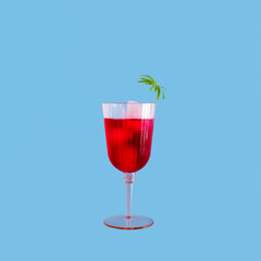 Pink cocktail glass, red refreshment drink, palm leaf decoration. Summer holiday relaxation.