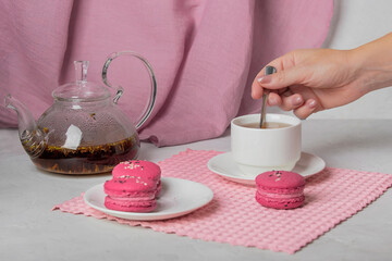 breakfast of herbal tea with lavender and sweet colorful dessert macarons on white background