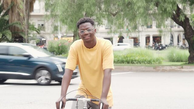 Smiling african american young man with a bicycle in the city. Sustainable mobility, millennial lifestyle