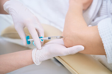 Close up of injection in the elbow for lady