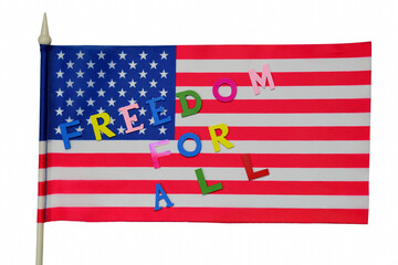 The text FREEDOM FOR ALL is laid out in colorful letters on a white background on the flag of the USA in support of the LGBT community