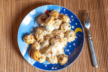 Dumplings with melted cheese and spices on a plate