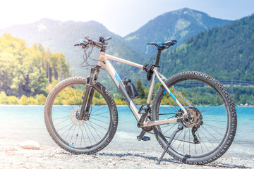 Fototapeta na wymiar The bike stands against the backdrop of mountains and a lake