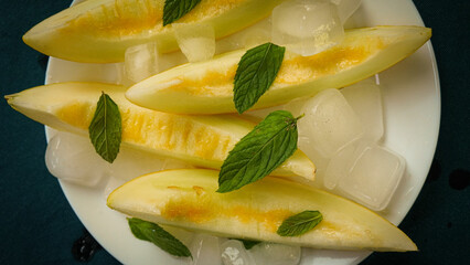 ripe melon with crushed ice and mint leaves, cut into pieces and slices