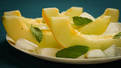 ripe melon with crushed ice and mint leaves, cut into pieces and slices