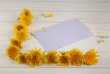 Front view on flower frame and card for your text on white table. Selective focus