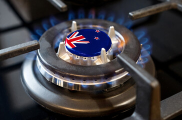 A burning gas burner of a home stove, in the middle of which a flag is depicted - New Zealand