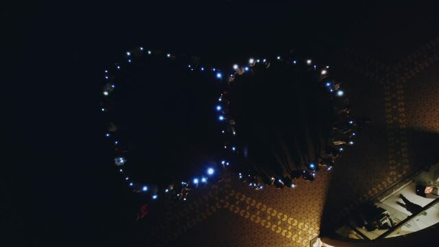 Flash mob figure 8, people waving flashlights, aerial photography