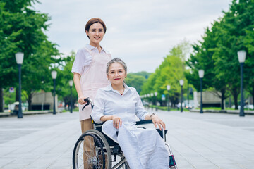 Obraz premium A woman in a wheelchair and young woman in an apron to care for