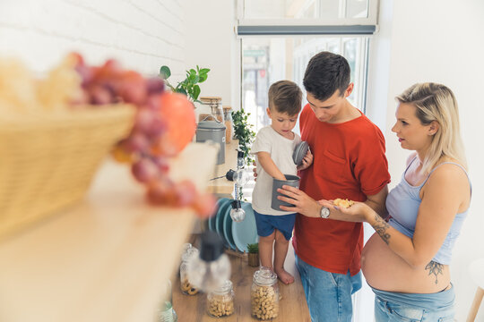 little boy checking things in the kitchen with his parents, family concept. High quality photo