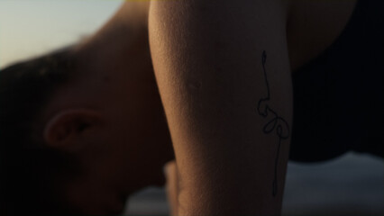Fototapeta premium Closeup girl making worm-up in front calm ocean close up. Woman training yoga.
