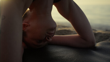 Closeup yogi girl standing on head summer evening. Woman making headstanding.