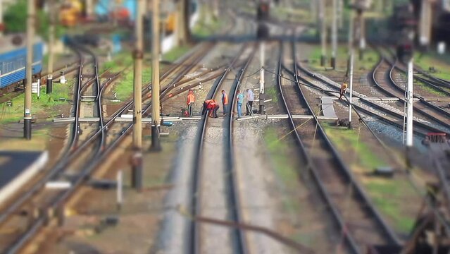 Railroad workers repairing a broken track. Time lapse. Tilt-shift effect. Miniature effect. Repairing railway. Rail tracks maintenance process. Mini train workers repair railroad