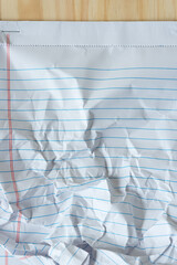 crumpled paper notepad on wood