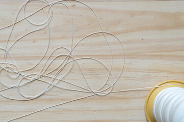spool of white nylon thread on a wooden surface