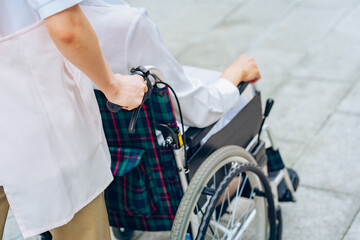 Fototapeta na wymiar 車椅子の女性と介護するエプロン姿の女性