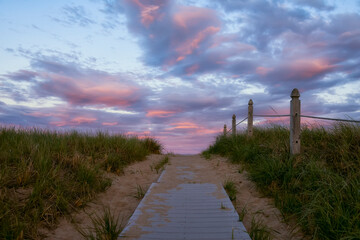 Path to the coast of the ocean from wooden boards at sunset. Sandy beach and sky on the ocean. USA. Maine.  © Ann Stryzhekin