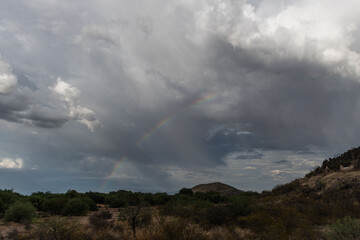 Dramatic sky and rainbow in Tucson, Arizona, near Mission San Xavier del Bac during monsoonal rainstorm