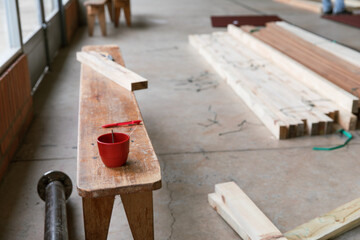 A work bench at a construction site or workshop with a cup of coffee and lumber. 