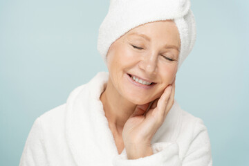 Beauty shot of senior woman in bathrobe after spa, her face with fresh skin and closed eyes - obrazy, fototapety, plakaty