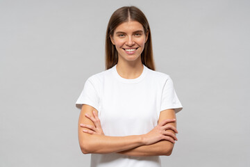 Portrait of young woman standing with arms crossed and smiling