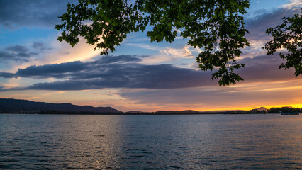 Fototapeta na wymiar Sommer Abend am schönen Bodensee mit bunten Wolken am Himmel zum Sonnenuntergang 