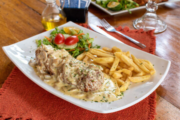 Delicious Gordon Blue with white sauce and fries, salad