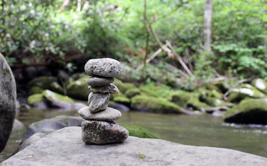 Fototapeta na wymiar A pile of zen stones next to a mountain stream.