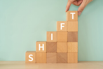 シフトのイメージ｜「SHIFT」と書かれたブロックと手
