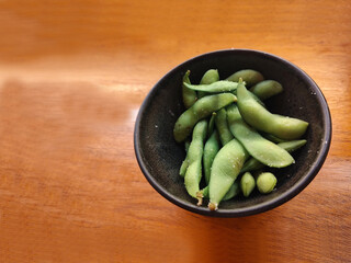 Edamame is a preparation of immature soybeans in the pod, found in cuisines with origins in Japan, East Asia. The pods are boiled or steamed and may be served with salt or other condiments.