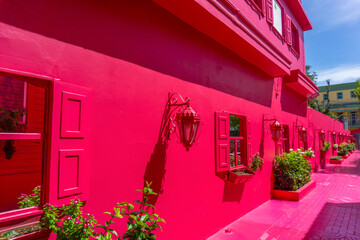 Fototapeta na wymiar Paseo de Donna Blanca - Pedestrian street painted in bright pink or red color located near Central Park in Puerto Plata, dominican Republic - July 2, 2022.
