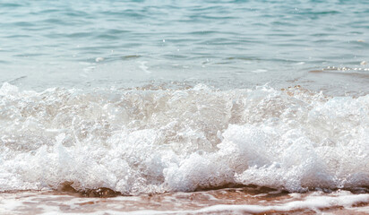 Fototapeta premium White foam of the sea at sandy beach